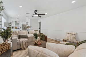 Living area with recessed lighting, wood finished floors, and a ceiling fan