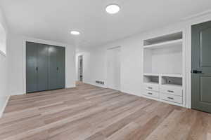 Unfurnished bedroom with light wood finished floors and a closet