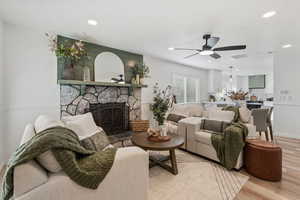 Living area featuring a fireplace, wood finished floors, recessed lighting, and ceiling fan