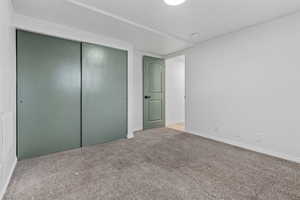 Unfurnished bedroom with light colored carpet and a closet