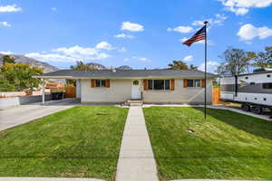 Single story home with an attached carport, brick siding, concrete driveway, and a mountain view