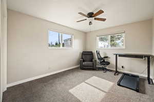 Office area featuring carpet floors, a textured ceiling, and a ceiling fan