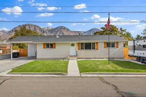 Ranch-style house with a mountain view, a carport, brick siding, and driveway
