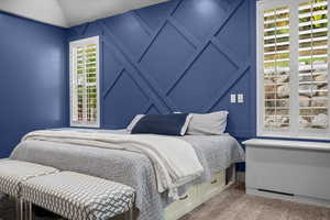 Carpeted bedroom featuring lofted ceiling
