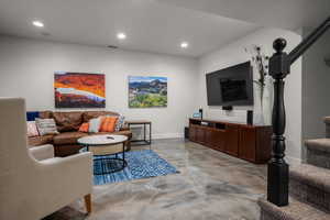 Living room with finished concrete floors and recessed lighting