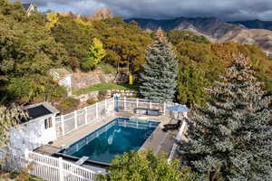 View of pool with a fenced backyard, a patio area, an outbuilding, and a view of trees