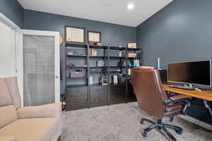 Office space featuring a textured ceiling and light carpet