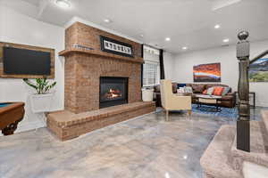 Living room with billiards, recessed lighting, finished concrete floors, a brick fireplace, and a textured ceiling