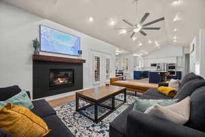 Living room featuring a tile fireplace, light wood-style flooring, recessed lighting, high vaulted ceiling, and ceiling fan