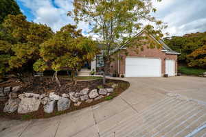 View of front facade featuring brick siding, concrete driveway, and a garage