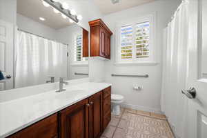 Bathroom featuring vanity, light tile patterned floors, and a shower with curtain