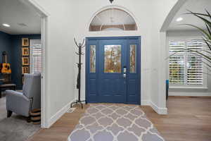 Foyer featuring recessed lighting, light wood-style floors, a textured ceiling, and arched walkways