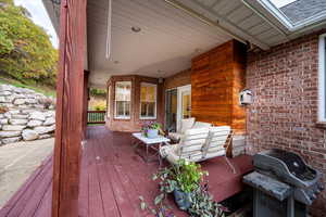 Wooden terrace featuring a grill