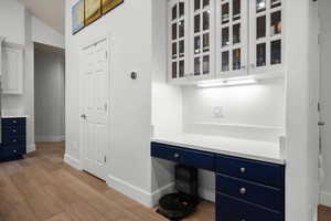 Unfurnished office featuring light wood-type flooring and vaulted ceiling