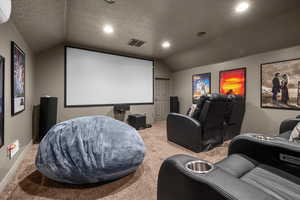 Carpeted cinema featuring lofted ceiling, a textured ceiling, recessed lighting, and a wall unit AC