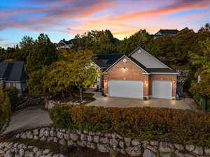 View of front of house with brick siding, an attached garage, concrete driveway, and solar panels