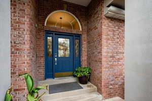 Property entrance featuring brick siding