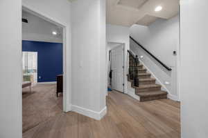 Stairs with recessed lighting and wood finished floors