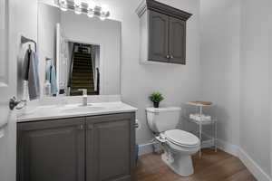 Half bathroom featuring vanity and wood finished floors