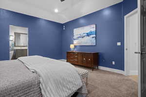 Carpeted bedroom featuring a ceiling fan and connected bathroom
