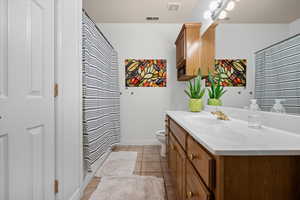 Full bath featuring vanity, light tile patterned floors, and curtained shower