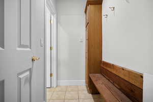 Mudroom with light tile patterned floors and baseboards