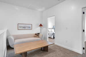 Living area featuring carpet flooring and attic access
