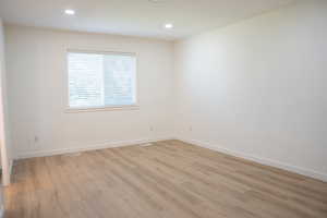 Spare room with light wood-style floors and recessed lighting