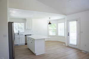 Kitchen featuring white cabinetry, stainless steel appliances, recessed lighting, decorative light fixtures, and light wood-type flooring