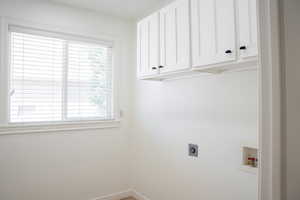 Laundry area with cabinet space, washer hookup, and hookup for an electric dryer