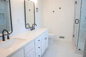 Bathroom with a stall shower, double vanity, and light tile patterned floors