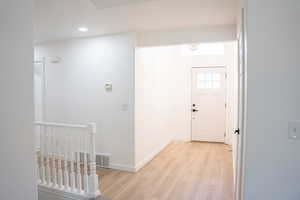 Foyer featuring light wood finished floors and recessed lighting