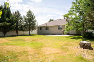 Rear view of property featuring a shingled roof and a patio area