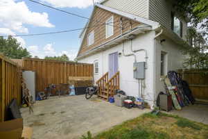 Back of house featuring a fenced backyard, a patio area, brick siding, and entry steps