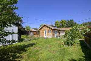Fenced backyard featuring an outbuilding