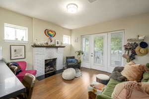 Living area featuring a brick fireplace, hardwood / wood-style floors, and a textured ceiling