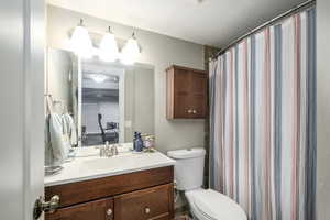 Bathroom with a textured ceiling, vanity, and a shower with curtain