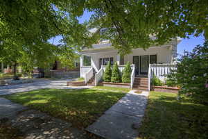 View of front of house with covered porch and a front yard