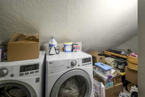 Washroom with independent washer and dryer and a textured ceiling