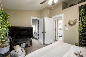Bedroom featuring carpet, a ceiling fan, a textured ceiling, and lofted ceiling