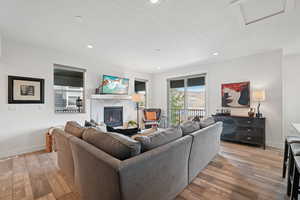 Living area with a premium fireplace, recessed lighting, a textured ceiling, and light wood finished floors