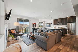 Living area featuring dark wood-type flooring, recessed lighting, a chandelier, and a textured ceiling