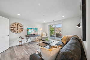 Living area with wood finished floors, recessed lighting, and a textured ceiling