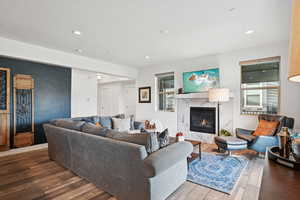 Living room with hardwood / wood-style floors, a high end fireplace, recessed lighting, and a textured ceiling
