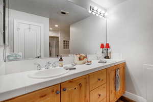 Full bath with double vanity en suite in primary bedroom