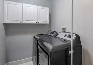 Laundry area, cabinet space, independent washer and dryer, and tile patterned floors