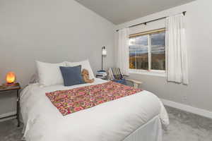 Existing decor. Second bedroom featuring carpet flooring and vaulted ceiling