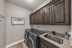 Laundry area featuring independent washer and dryer and cabinet space