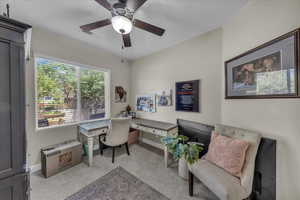 Office with light carpet and ceiling fan