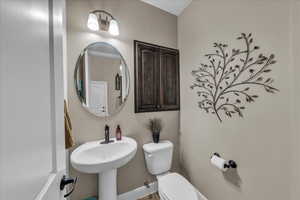 Half bathroom featuring toilet and baseboards